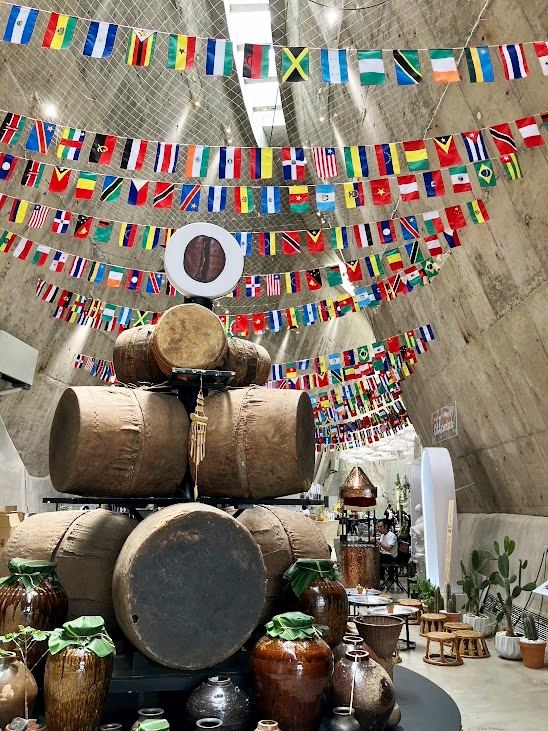 バンメトート・コーヒー博物館の館内に並ぶ木製の樽と各国の国旗ガーランド