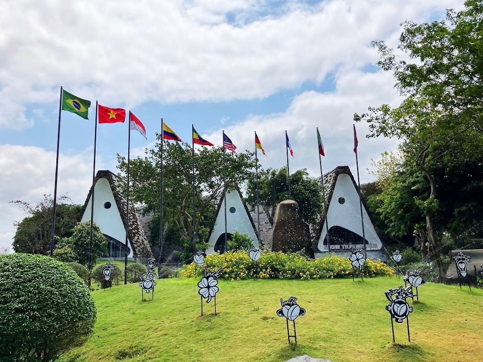 バンメトート・コーヒー博物館エリアに設けられた三角形の伝統建築風パビリオンと並ぶ国旗