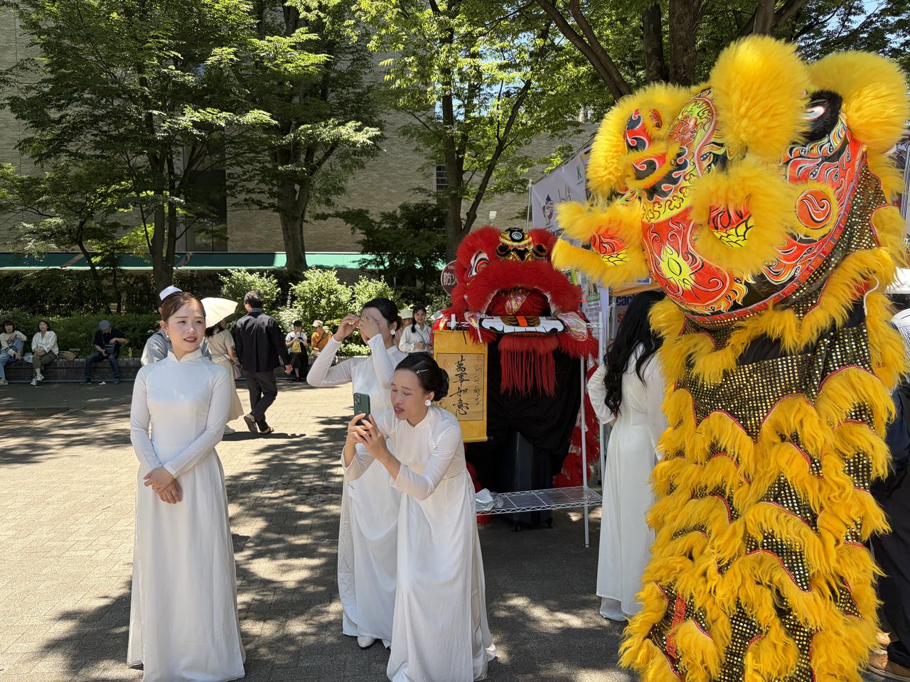 Vietnamese people in Ao Dai and a lion dance performance